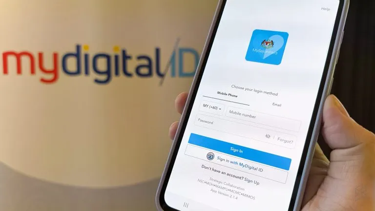 Malaysian user accessing online services through MyDigital ID with a MyKad nearby